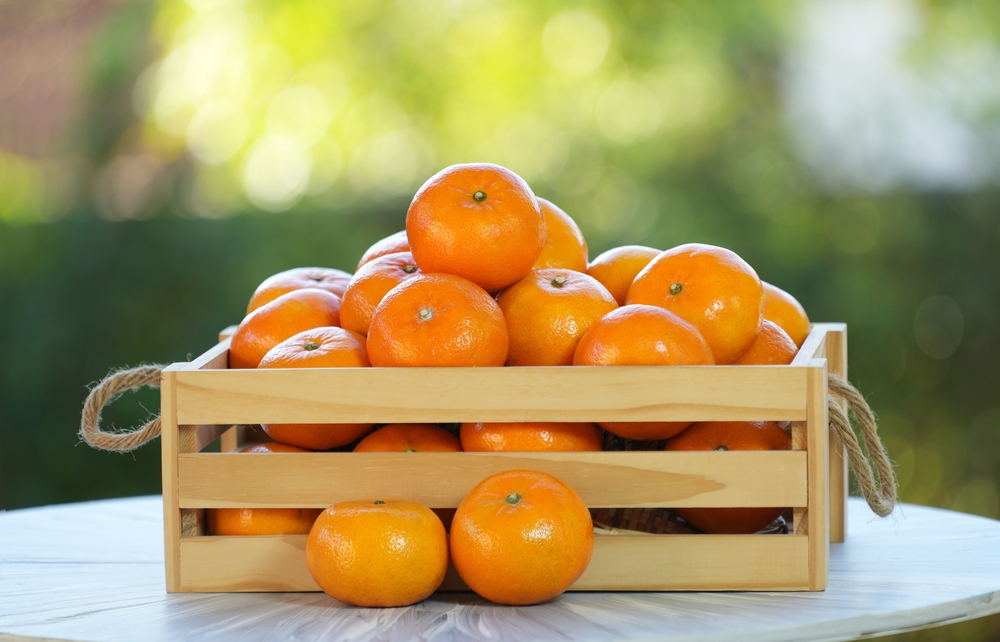 Mandarin,Oranges,In,Wooden,Crate,On,Green,Natural,Garden,Blur